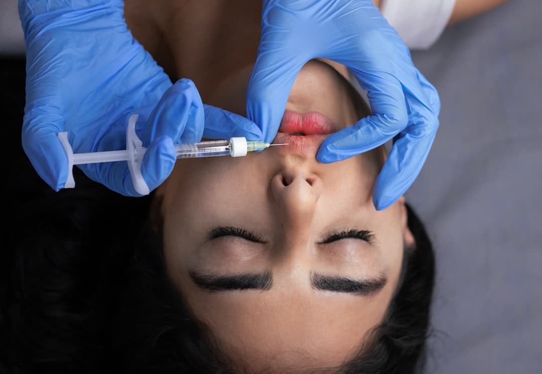 Aesthetic injector preparing Botox vial in clean treatment room afternoon light
