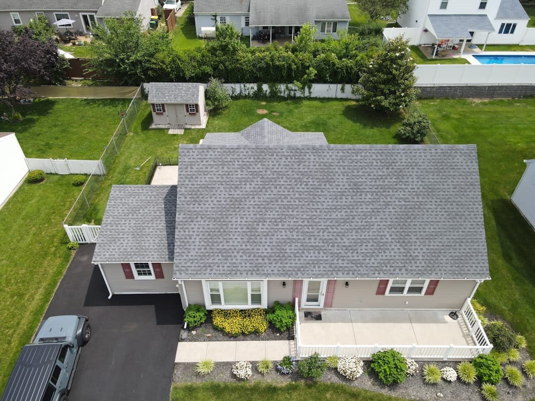 Aerial view of suburban house with grey shingle roof and backyard pool, the regular-weather Tampa roof before storm season hits