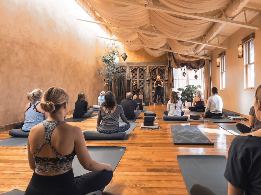 packed yoga class on grey mats, three quarters of these trial-class folks ghost by next week
