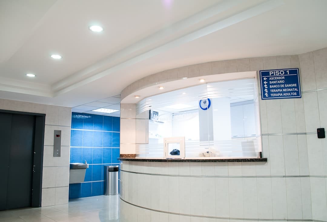 Clinic reception lobby with directory wall signage, dormant patient rebook arrives mid-shift