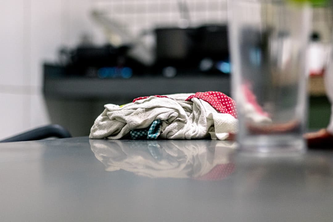 crumpled cleaning cloth on a grey counter, crew mid-job while the phone rings out