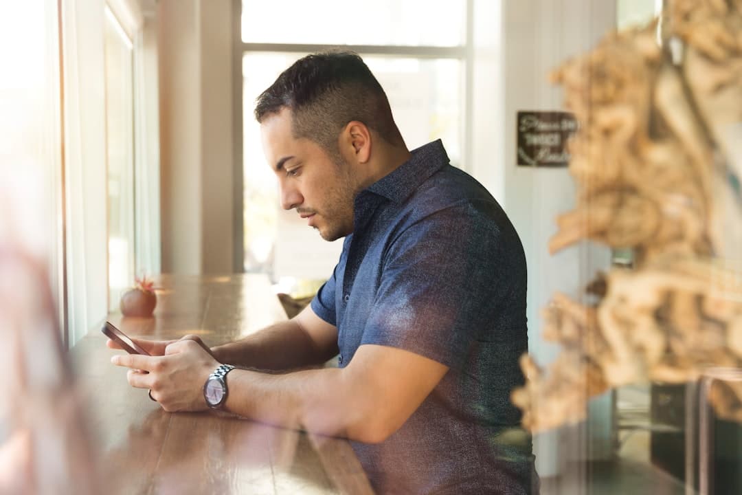 Service business owner reviewing lead generation system notifications on a phone between client appointments