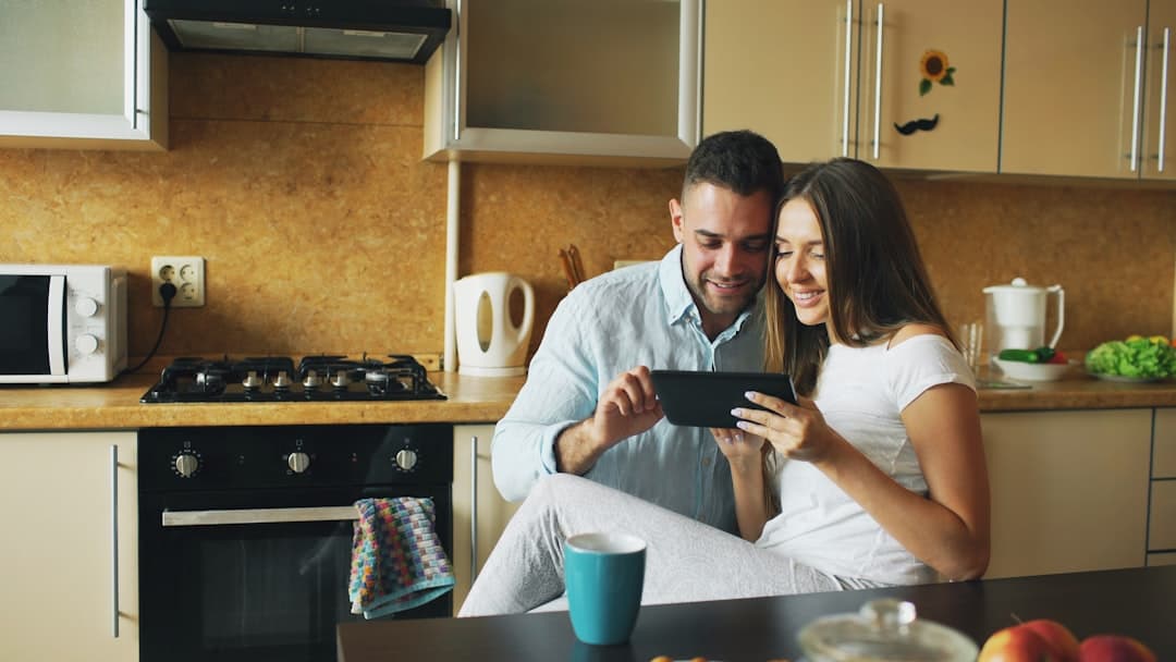 Couple reviewing real estate options on tablet together, finally aligned on budget