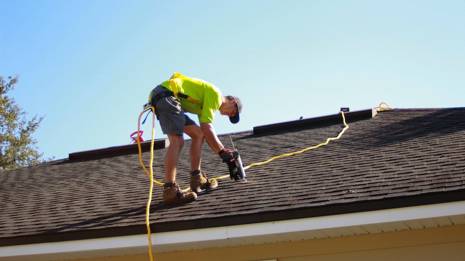 Roofer installing shingles on a residential roof in the off season