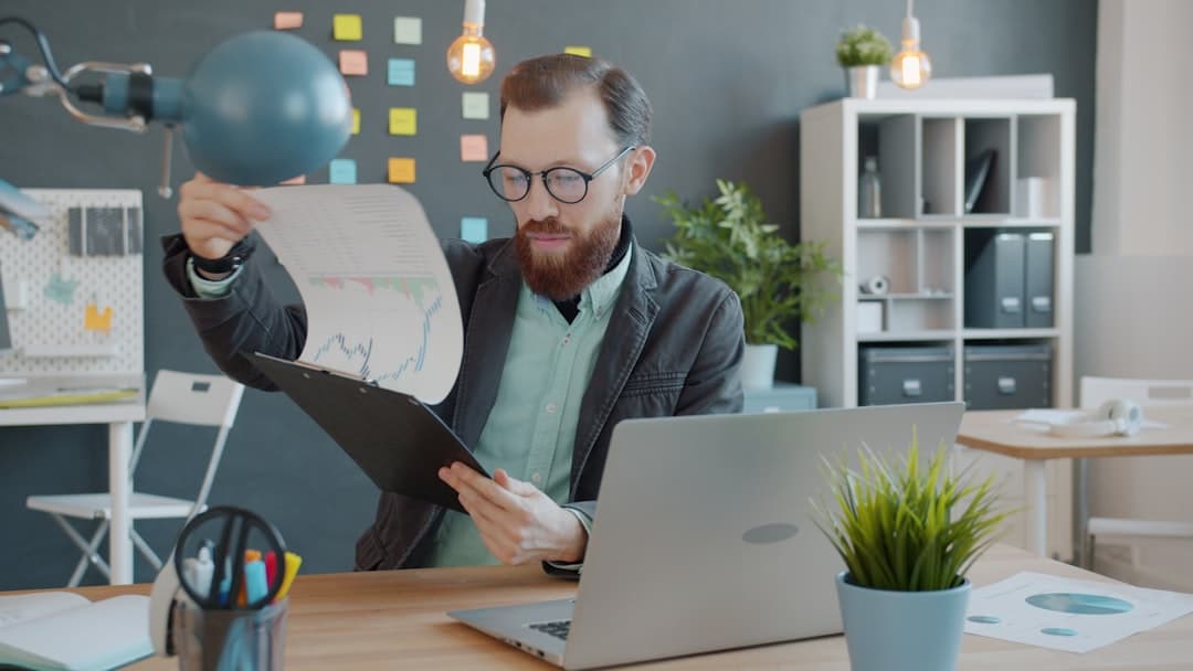 Small business owner working on laptop, AI tools quietly running in the background