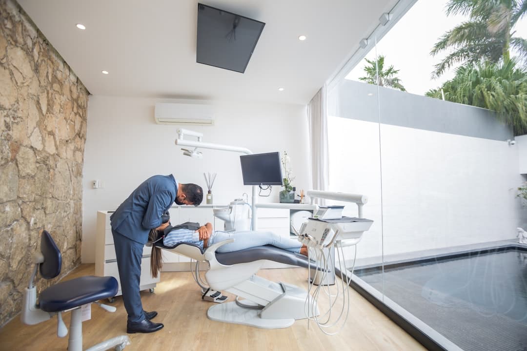 Hygienist at a dental practice Jacksonville reviewing reactivation records on a tablet, the kind of San Marco 32207 operatory the playbook keeps full