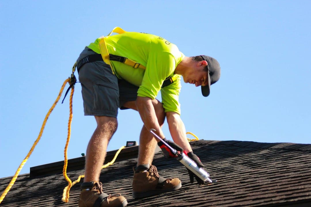 Homeowner reviewing a marked-up Tucson roofing report on a tablet with an indoor water stain spreading behind them