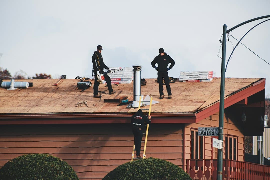 Roofer using a tablet for automated roof assessments on a shingle roof instead of a tape measure