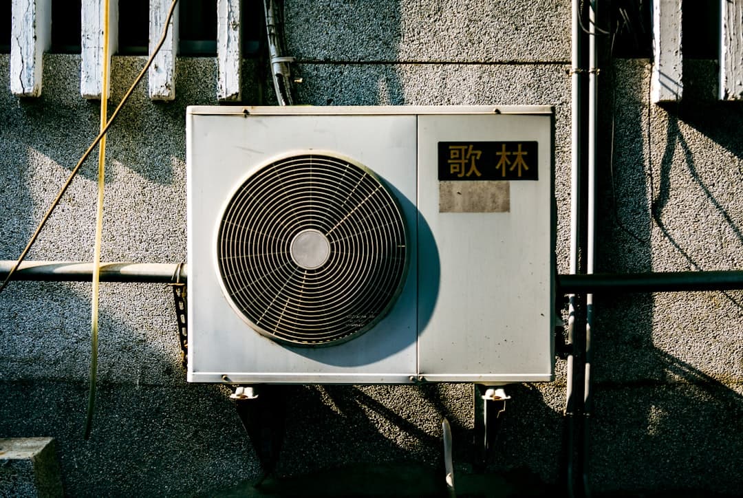 white air conditioner condenser unit mounted on a residential building exterior, the dispatch call nobody answered yet
