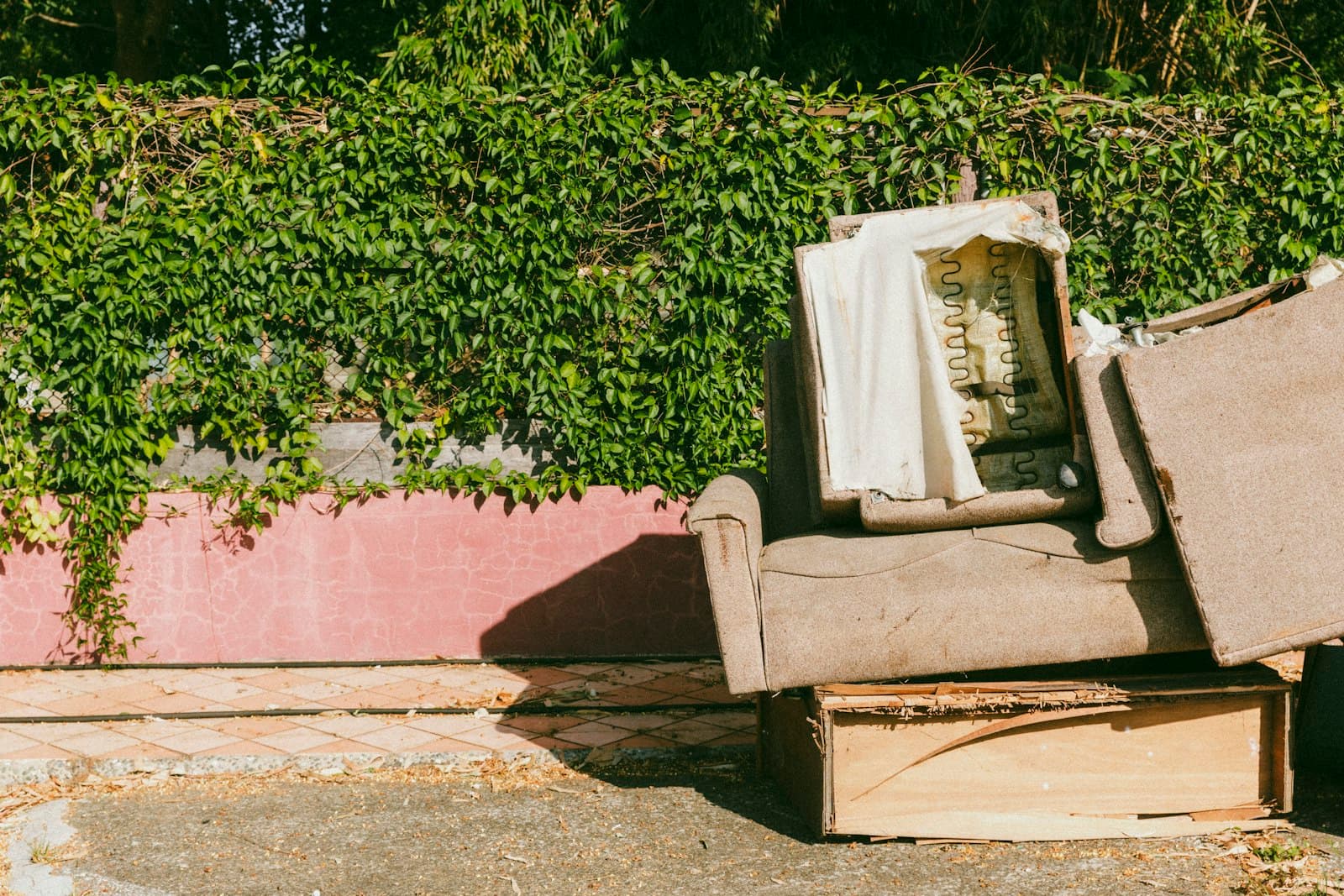 Old couch and junk dumped at the curb, the cleanout a property manager needs gone today