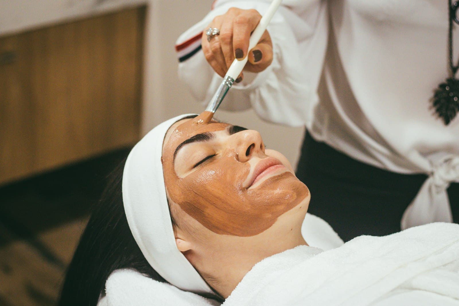 Woman getting a facial mask treatment at a spa, the kind of regular who quietly stopped rebooking