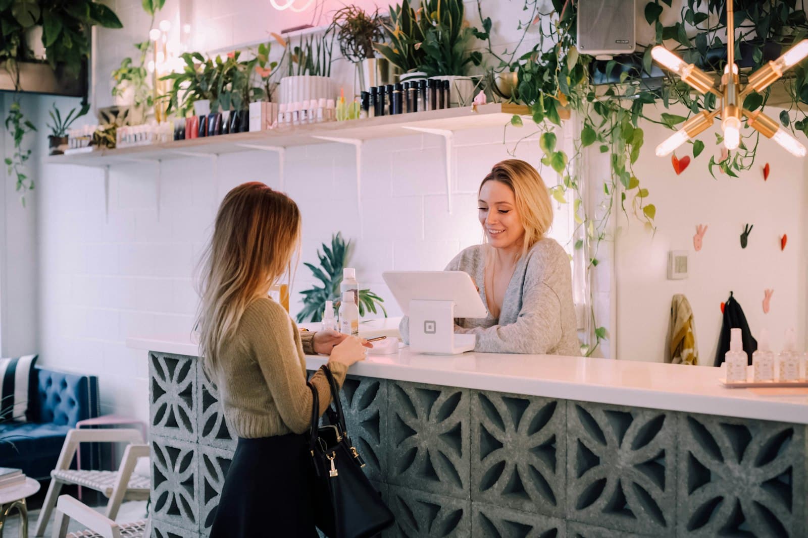 Client checking out at a bright spa reception counter, the front desk a lapsed patient never comes back to