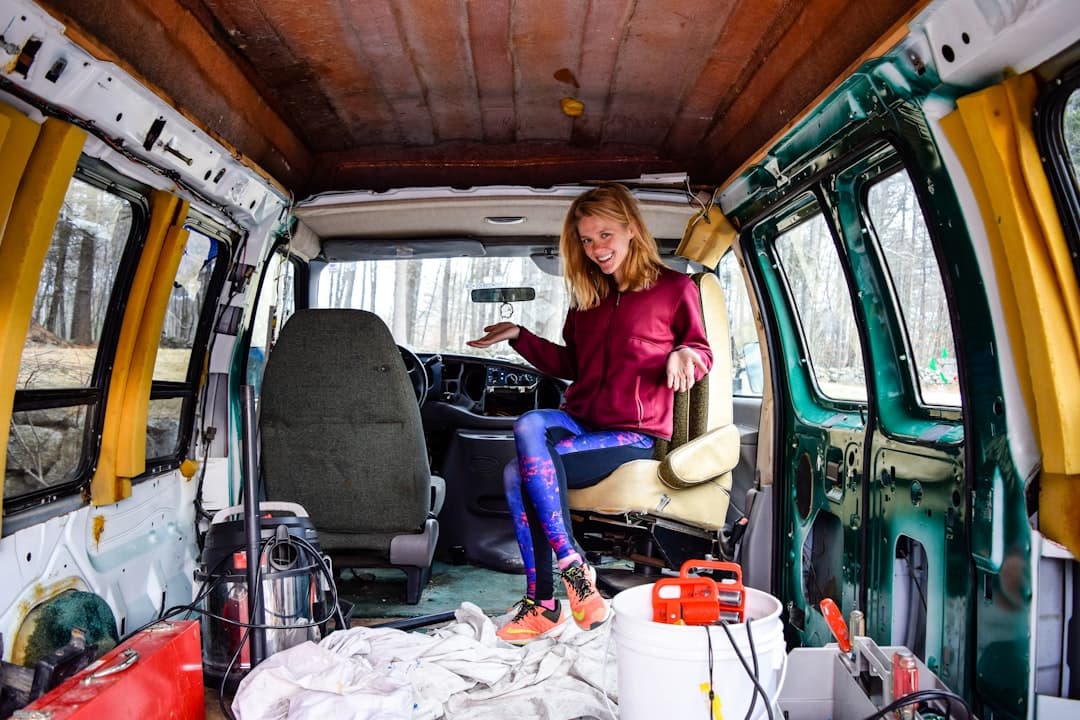 Plumber in a work van checking text messages, contractor leads answer faster than voicemail